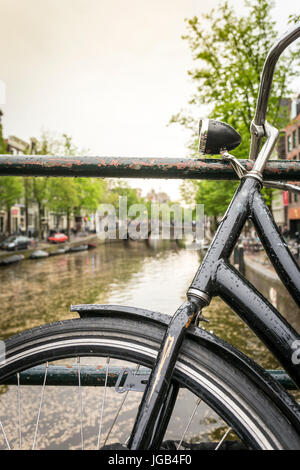 Vélo noir sur canal à Amsterdam, Pays-Bas Banque D'Images