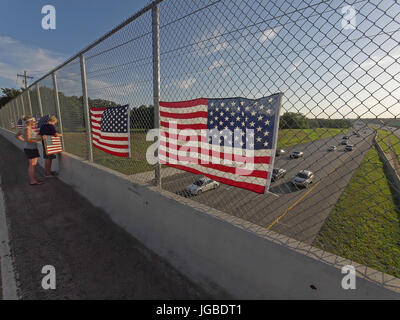 Célébration de la quatrième de juillet vacances d'étudiants réagissent à une suggestion d'enseignants d'accrocher le drapeau américain sur une clôture donnant sur une autoroute entre Dallas et Fort Worth, Texas. Les conducteurs ont pris des photos avec leur téléphone cellulaire et la police fait enlever les drapeaux Banque D'Images