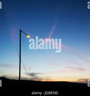 Street light & jet trails at Dusk, Whitehead, L'Irlande du Nord. Banque D'Images