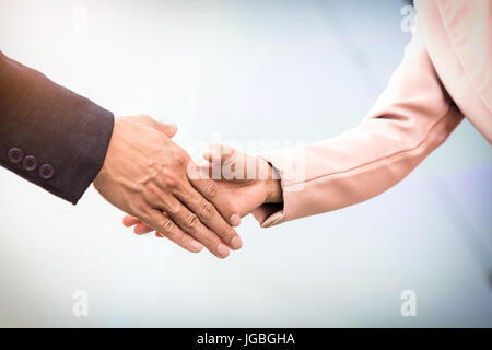 Libre réunion amicale poignée de main entre femme et homme d'affaires avec la lumière du soleil. Banque D'Images