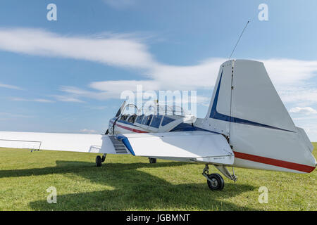 Moteur unique siège deux avions, l'utilitaire civile petit avion blanc, rouge et bleu strip est remorqué par un planeur sur une journée ensoleillée. Banque D'Images