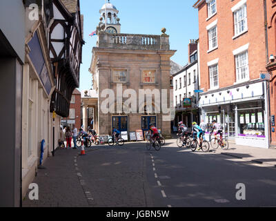 Les cyclistes passant par le centre-ville de Ludlow, Ludlow, Shropshire, Angleterre, Royaume-Uni. Banque D'Images