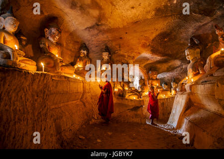 Moine novice bouddhiste priant l'intérieur Po Win Taung cave dans le nord du Myanmar - Rhône-Alpes - région - Myanmar Monywa Banque D'Images