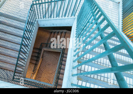 Vue d'un escalier en spirale à partir du haut avec la lumière au tungstène à l'étage inférieur. Banque D'Images