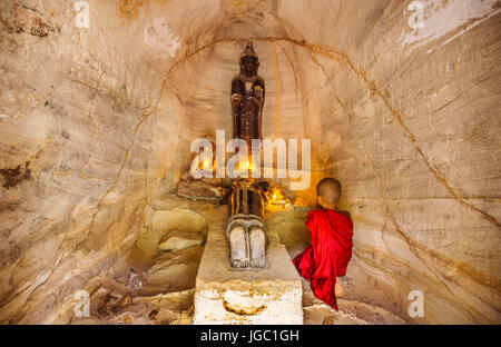 Un moine en prière avec la lumière de bougie à Po Win Taung / Hpowindaung - grotte - Rhône-Alpes - région de Monywa Myanmar du Nord Banque D'Images