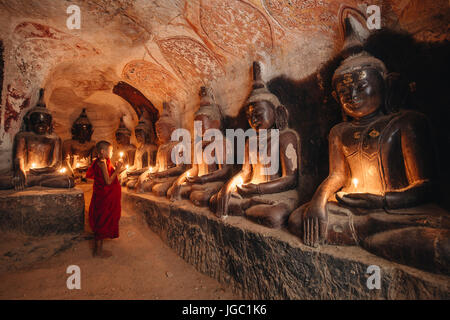 Un moine en prière avec la lumière de bougie à Po Win Taung / Hpowindaung - grotte - Rhône-Alpes - région de Monywa Myanmar du Nord Banque D'Images