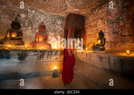 Un moine en prière avec la lumière de bougie à Po Win Taung / Hpowindaung - grotte - Rhône-Alpes - région de Monywa Myanmar du Nord Banque D'Images