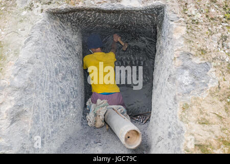 Man carving rock d'un traditionnel de sépulture dans Tana Toraja de Sulawesi, Indonésie Banque D'Images