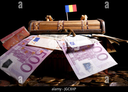 Drapeau roumain sur le dessus de caisse pleine d'argent Banque D'Images