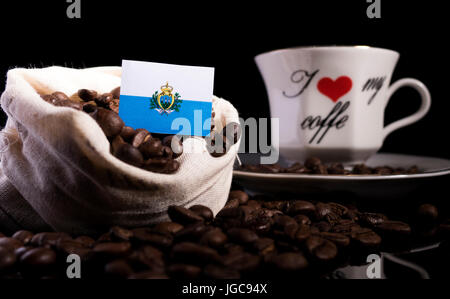 Saint-marin drapeau dans un sac avec les grains de café isolé sur fond noir Banque D'Images