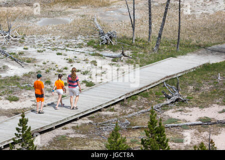 Une femme et deux enfants sont à pied sur la promenade des artistes Paintpots Trail dans le Parc National de Yellowstone Banque D'Images