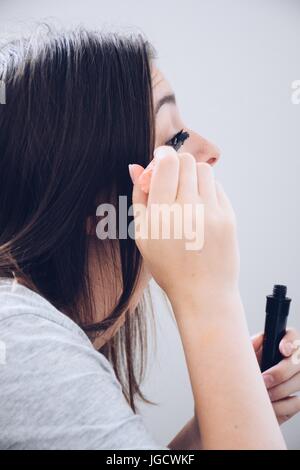 Teenage girl applying mascara Banque D'Images