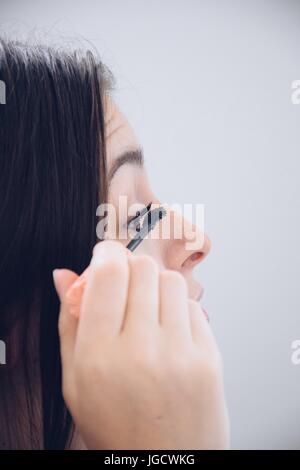 Teenage girl applying mascara Banque D'Images