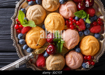 Biscuits multicolores avec des framboises, fraises, cerises et groseilles close-up sur la table horizontale vue du dessus. Banque D'Images