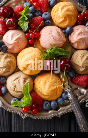 Biscuits multicolores avec des framboises, fraises, cerises, groseilles et gros plan sur la table. vertical Vue de dessus Banque D'Images