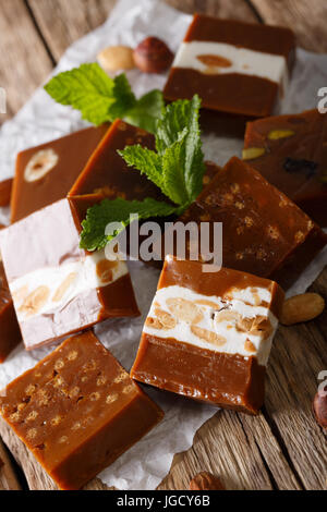 Délicieux caramel aux noix caramélisées close-up sur le parchemin sur la table verticale. Banque D'Images