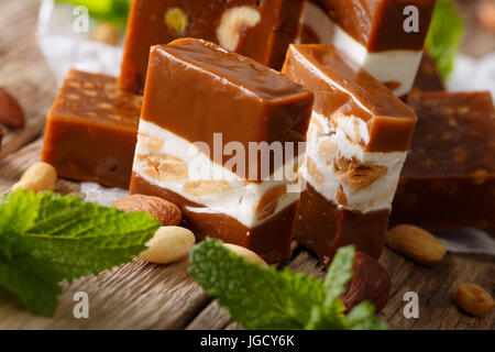 Avec le caramel et nougat aux amandes, menthe fraîche macro sur la table horizontale. Banque D'Images