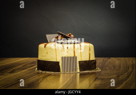 Ensemble crémeux délicieux gâteau au chocolat blanc aux châtaignes sur le dessus sur fond sombre Banque D'Images