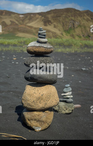 Cairn sur la plage de sable noir Banque D'Images