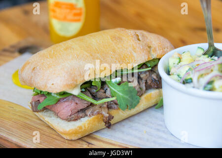 Côtes de bœuf, roquette, et l'ail mayo sandwich, salade de pois chiches à la courgette et viande Restaurant Pain, Gastown, Vancouver, Canada Banque D'Images