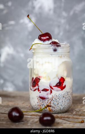 Avec la crème glacée vegan chia seeds et les cerises dans un bocal. L'amour pour une saine nourriture vegan concept. Banque D'Images