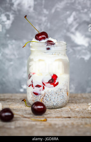 Avec la crème glacée vegan chia seeds et les cerises dans un bocal. L'amour pour une saine nourriture vegan concept. Banque D'Images