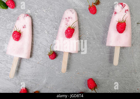 Glace à la framboise sur fond gris. Trois sucettes glacées. vue d'en haut. des Banque D'Images