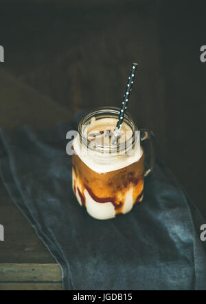 Caramel macciato glacé café avec du lait dans un pot avec de la paille Banque D'Images