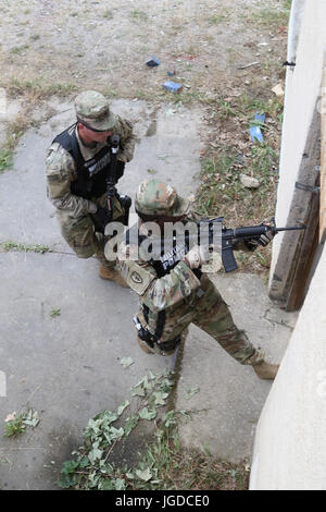 La police militaire entrer dans un bâtiment qui a été reprise par une personne hostile avec une arme à feu au cours d'un scénario de formation de tir le 28 juin 2017 à JMRC en Hohenfels, Allemagne. La 591e compagnie MP, 93e Bataillon, MP MP 89e Brigade à Fort Bliss, au Texas est la formation en préparation de leur KFOR MNBG-e mission de sécurité. (U.S. Photo de l'armée par le sergent. Nicolas Farina) Banque D'Images