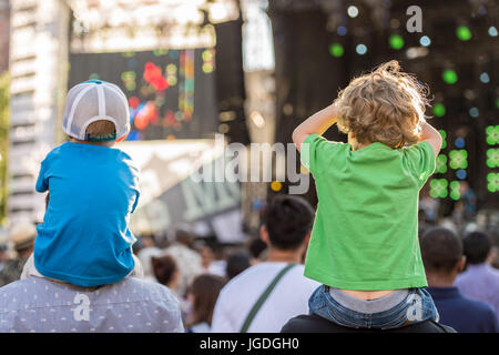 Montréal, le 3 juillet 2017 : deux garçons assis sur les épaules de leurs pères à la recherche à un spectacle au festival de Jazz de Montréal Banque D'Images