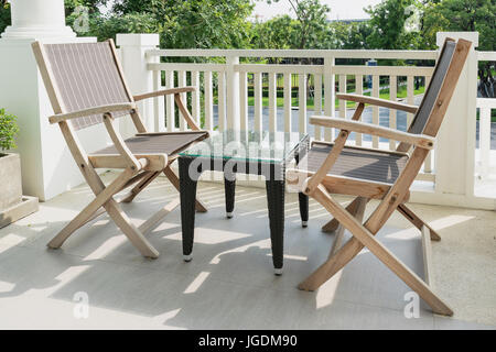 Des chaises en bois sur balcon donnant sur un jardin moderne Banque D'Images