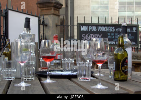 Pub disco club public house table avec des verres et des bouteilles de boissons cidre bière vin ivre vide tables en bois Banque D'Images