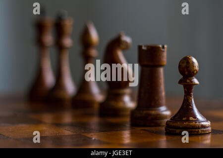 Pièces des échecs en bois ancienne sur un ancien échiquier. Banque D'Images