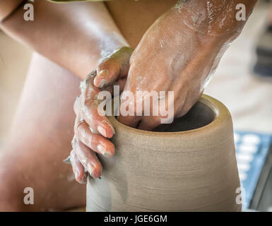 Mains d'un potier façonner un vase sur un tour de potier. Banque D'Images