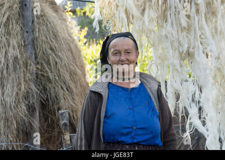 Une femme avec la laine de mouton à sécher à l'air libre dans le Maramures femme régionale avec la laine de mouton à sécher à l'air libre dans la région de Maramures Banque D'Images