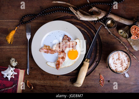 Le petit-déjeuner avec du bacon et des œufs de cappuccino sur table en bois. Boutique hotel de style vintage. Vue d'en haut. Banque D'Images