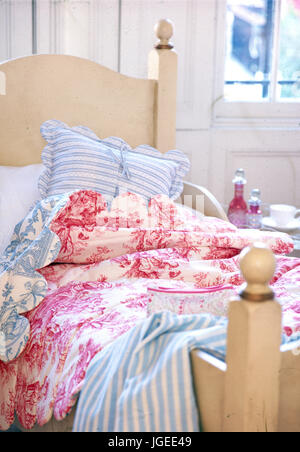 Toile de Jouy rose sur le lit avec couette Oreiller rayés bleus et feuilles Banque D'Images