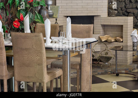 Intérieur d'un vieux restaurant de vieilles chaises, table en verre et une cheminée. Banque D'Images