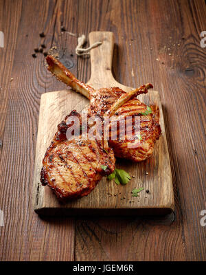 Des steaks grillés sur table en bois Banque D'Images