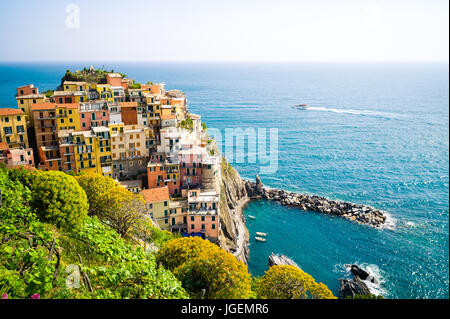 Vue aérienne de Manarola, une des villes des Cinque Terre en Ligurie, Italie, avec des maisons suspendues à la falaise au-dessus de la mer. Banque D'Images