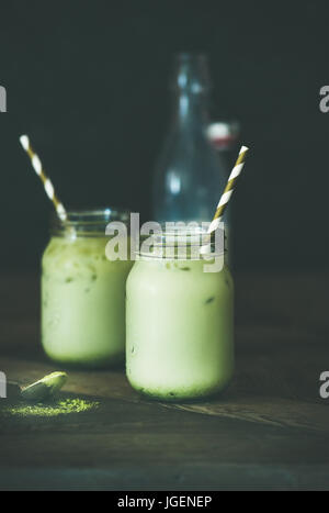 Noix de coco glacée rafraîchissante boisson matcha latte en pots, table en bois Banque D'Images