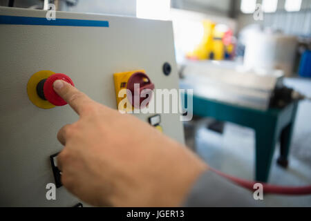 Part en appuyant sur un bouton de commande à l'usine Banque D'Images