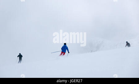 Les skieurs dans un brouillard épais sur la pente de ski dans la station de ski. Banque D'Images