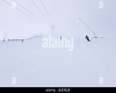 Les skieurs dans un brouillard épais sur la pente de ski dans la station de ski. Banque D'Images