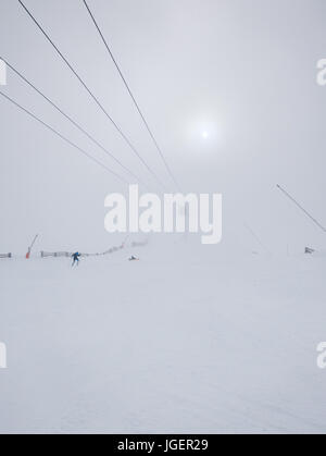 Les skieurs dans un brouillard épais sur la pente de ski dans la station de ski. Banque D'Images