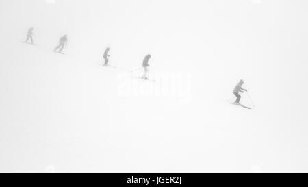 Les skieurs dans un brouillard épais sur la pente de ski dans la station de ski. Banque D'Images