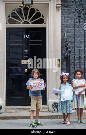 (Gauche-droite) Johnny Miller-Cole, Suzie et Leonie Ali Ali, livrer des dizaines de milliers de messages d'amour de plus de 60 écoles à travers Londres, Birmingham, Manchester, West Sussex et l'île de Wight au 10 Downing Street, Londres, dans le cadre de la campagne Save nos écoles. Banque D'Images