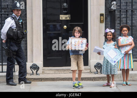 (Gauche-droite) Johnny Miller-Cole, Suzie et Leonie Ali Ali, livrer des dizaines de milliers de messages d'amour de plus de 60 écoles à travers Londres, Birmingham, Manchester, West Sussex et l'île de Wight au 10 Downing Street, Londres, dans le cadre de la campagne Save nos écoles. Banque D'Images