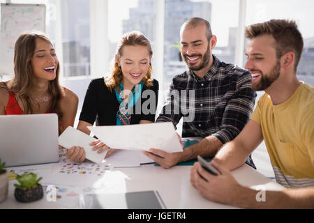 Smiling business executives discussing document sur papier Banque D'Images