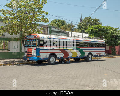 Un vieux bus scolaires de l'Amérique du Nord utilisé comme un autobus interurbain "Chicken Bus" à la capitale du Nicaragua Managua de Corinto, deux hommes l'Repaur Banque D'Images